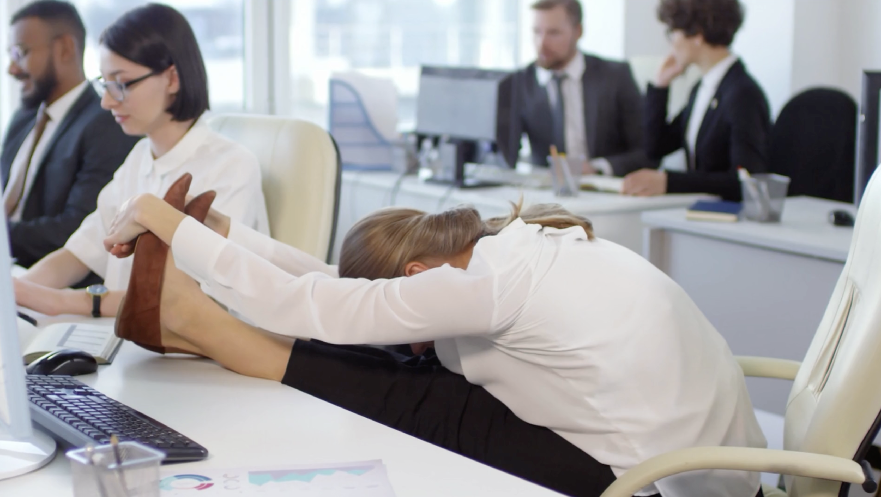 Frau hält im Büro ihren Rücken gesund und dehnt sich nach vorne